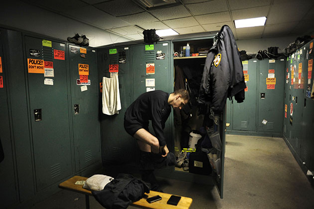 An officer sheds his civilian clothes and gets into uniform.