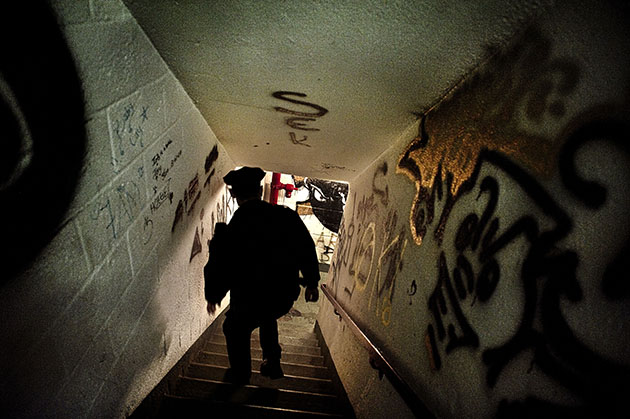 Cop walking down a graffit-covered stairwell