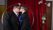 Two people kissing inside a metal hoop.