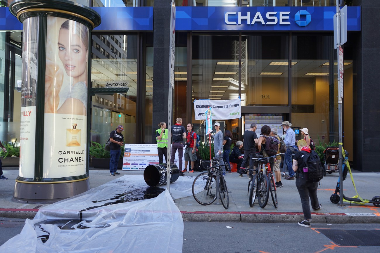 A group of activists with the Rainforest Action Network spilled mock oil outside a Chase Bank location.