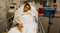 A child with brown skin lying down in an emergency room bed