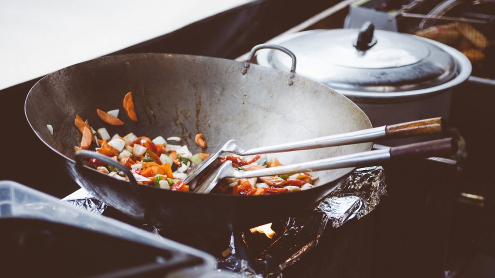 Stir fry wok being cooked over a gas stove