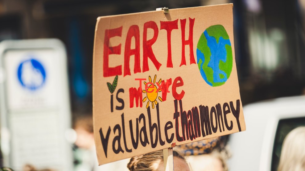 A protest sign that says "Earth is more valuable than money."