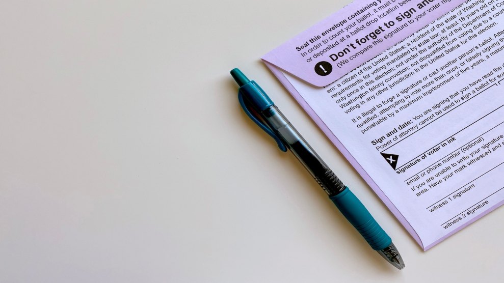 A photo of a purple envelope of an absentee ballot and a teal pen next to it.