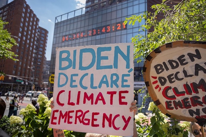 A sign at a protest that says, "Biden Declare Climate Emergency"