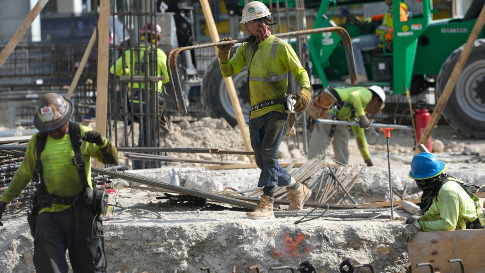 People working at a construction site, wearing neon uniforms