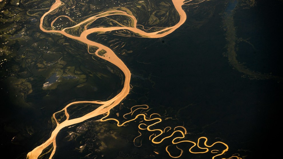 The amazon river, colored light brown, wriggles through a dark green landscape.