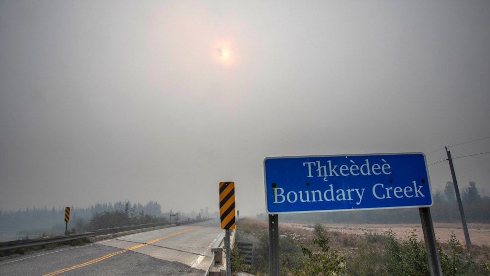 A sign that says "Thkeedee Boundary Creek" surrounded by smoke