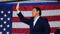 Ron DeSantis waves from a stage in Iowa.