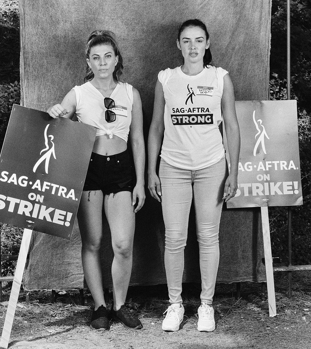 two women strikers standing with signs