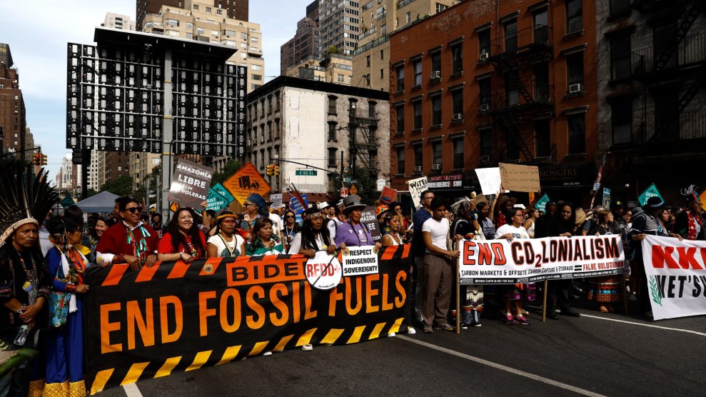 Un gruppo protesta con un grande striscione con la scritta "Biden mette fine ai combustibili fossili."