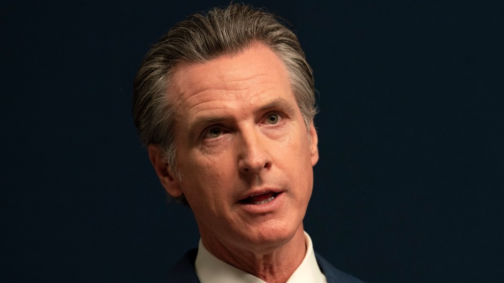 California Governor Gavin Newsom looking serious with a dark background behind him.