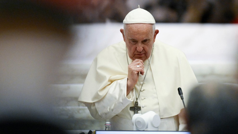 Paus Franciscus kijkt naar beneden met zijn hand naar zijn kin.
