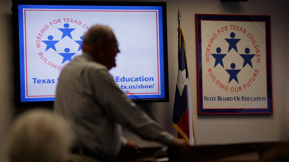 White person stands blurred in front of a white sign that says "Texas Board of Education Working for Texas Children Protecting Our Future."