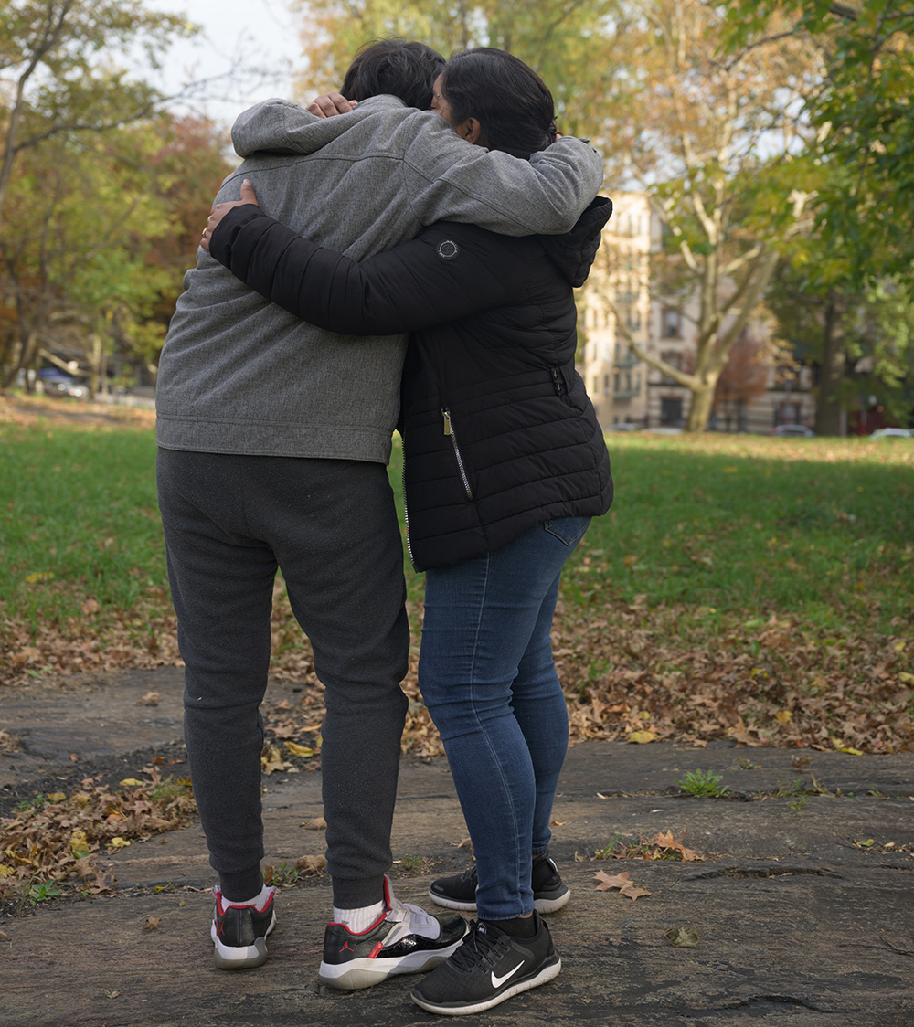 Mother and son hugging in a park.