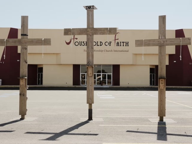 Front of the Household of Faith, which is a beige building, with three wooden crosses up front