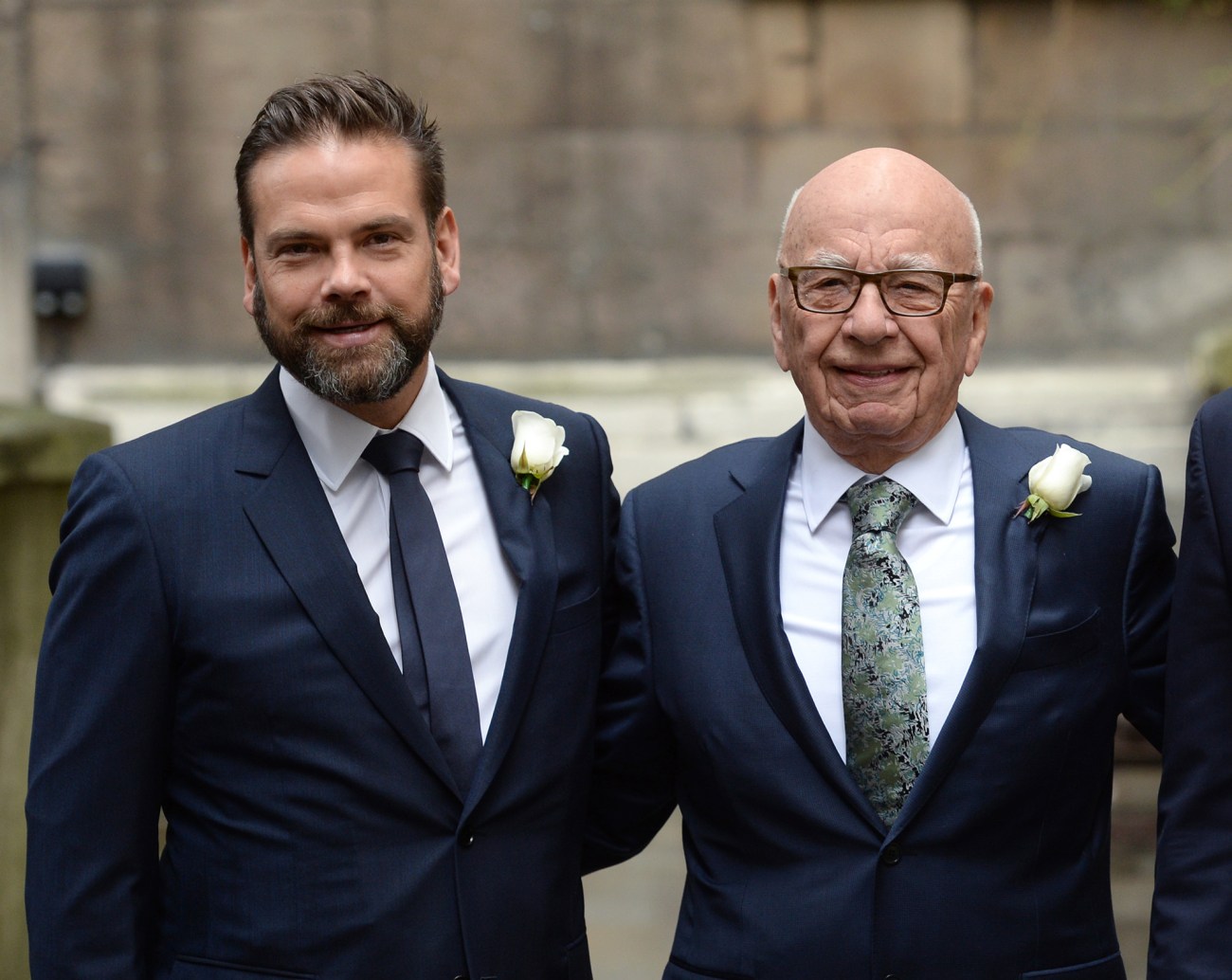 Lachlan and Rupert Murdoch, smiling, wearing suits.