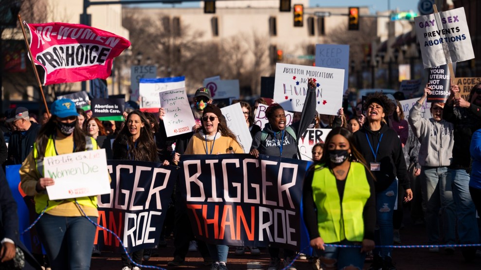 Protestors march through Texas with signs reading "bigger than Roe."