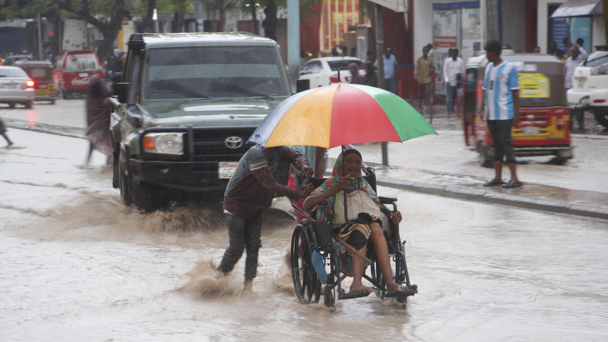A Somali woman is pulled on a wheelchair through a flooded street in Mogadishu, Somalia.