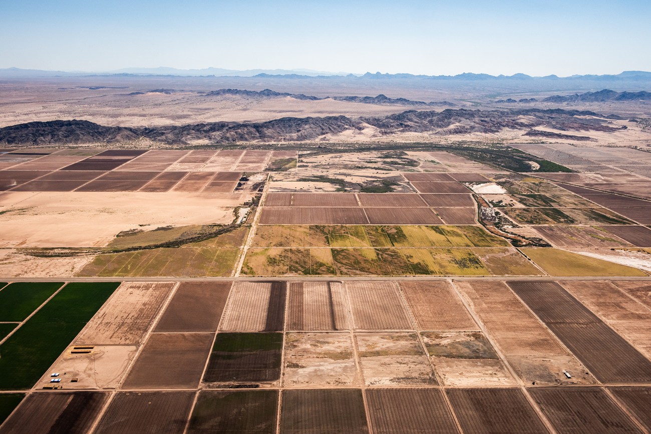 Overview of arid farmland near desertous mountain area.