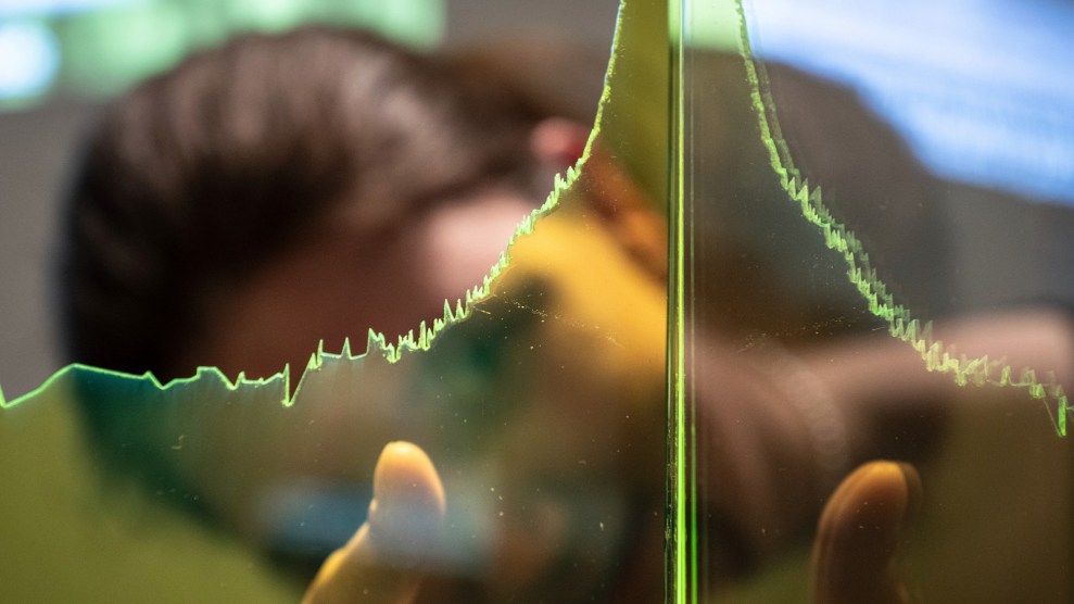 A person with long black hair and a beard looks through a green glass display of the Keeling Curve.