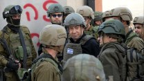 Israeli Prime Minister Benjamin Netanyahu, center, wears a protective vest and helmet as he receives a security briefing with commanders and soldiers in the northern Gaza Strip, on Monday