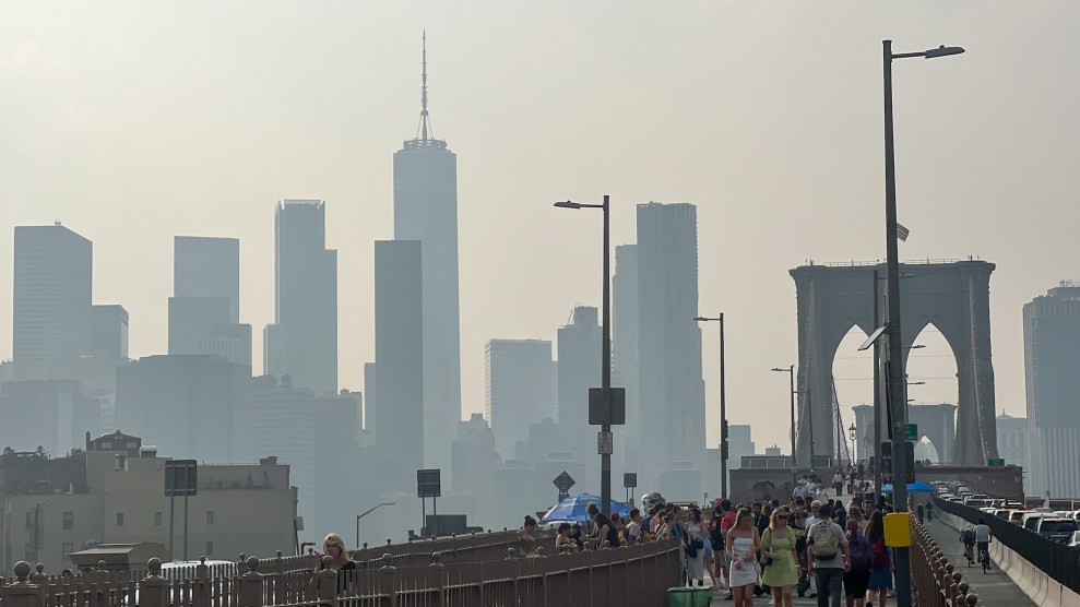 The Brooklyn Bridge and NYC skyscrapers shrouded in smoke with some people walking on the bridge