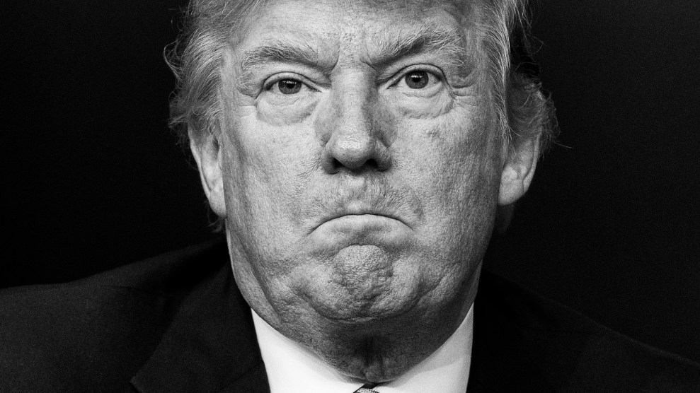 Close-up black and white photo of Donald Trump with his lips pursed, frowning.