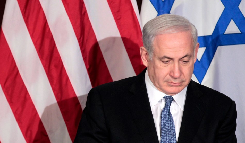 Benjamin Netanyahu in front of an American and Israeli flag