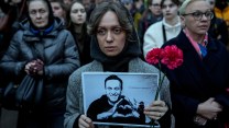 A woman holding a photo of Navalny