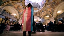 A protestor wears the transgender flag while standing in the Missouri Statehouse.