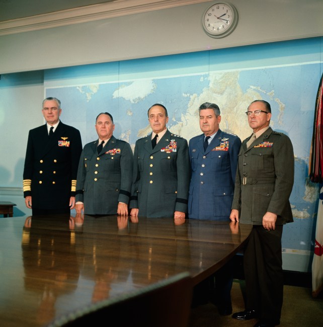 MIlitary men standing around a table.