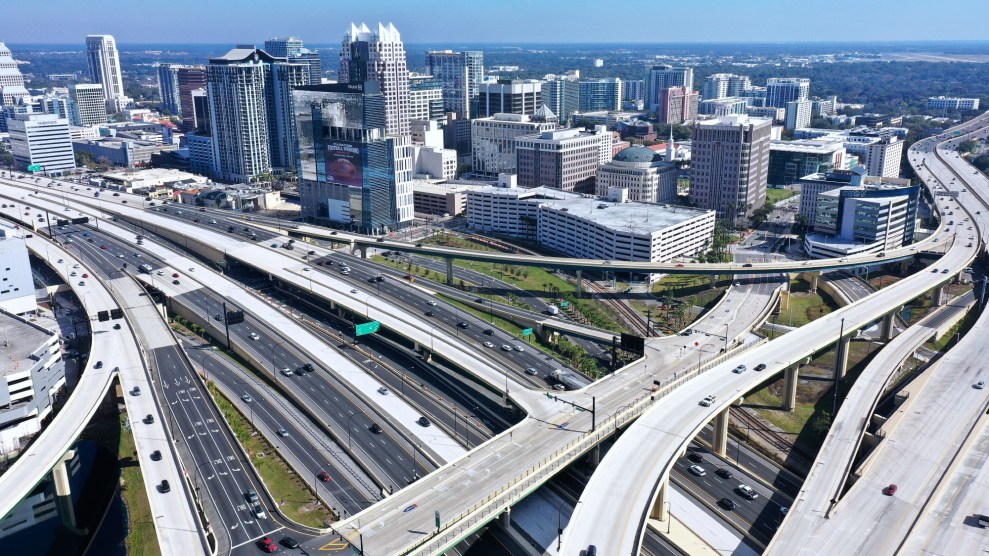 Several highways criss-cross over each other in front of a city skyline.