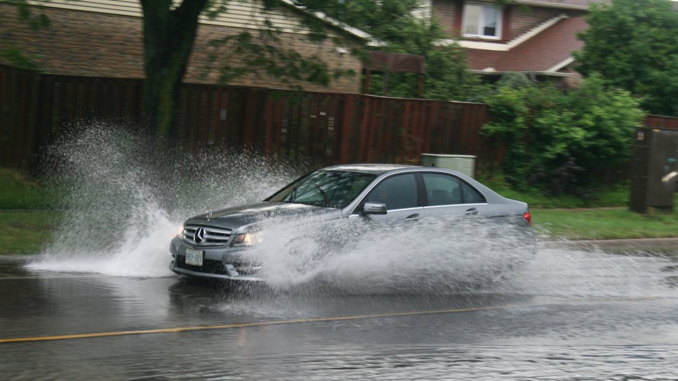 A car driving through a street that is flooded