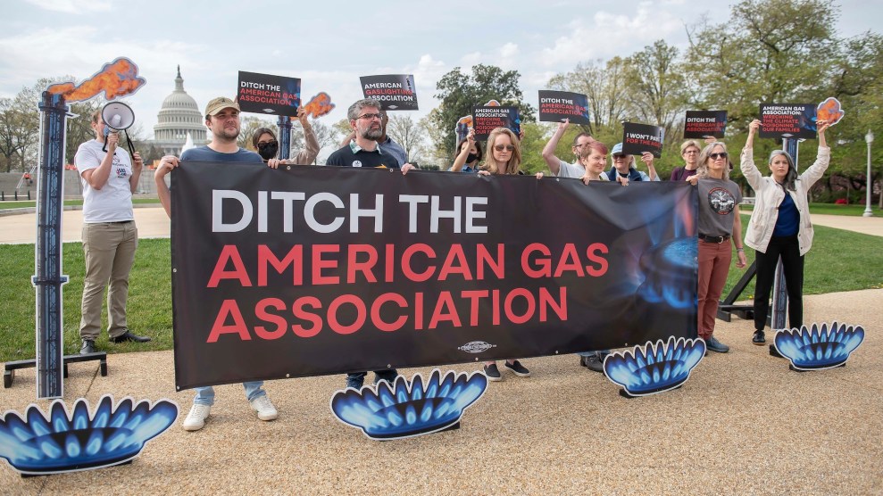 Protestors standing in an outside area with the Congress building in the background with signs that say "Ditch the American Gas Association"
