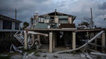 A destroyed house with cloudy skies in the background