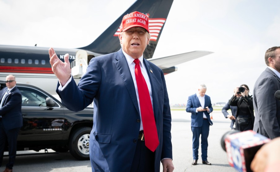 Trump at an airport, in front of his jet.