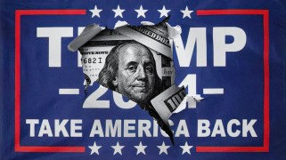 A hole has been torn in a "Trump 2024" sign; the face of Ben Franklin on a $100 bill peers out through the tear.