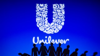 Unilever logo is displayed behind cut out paper figures chain.