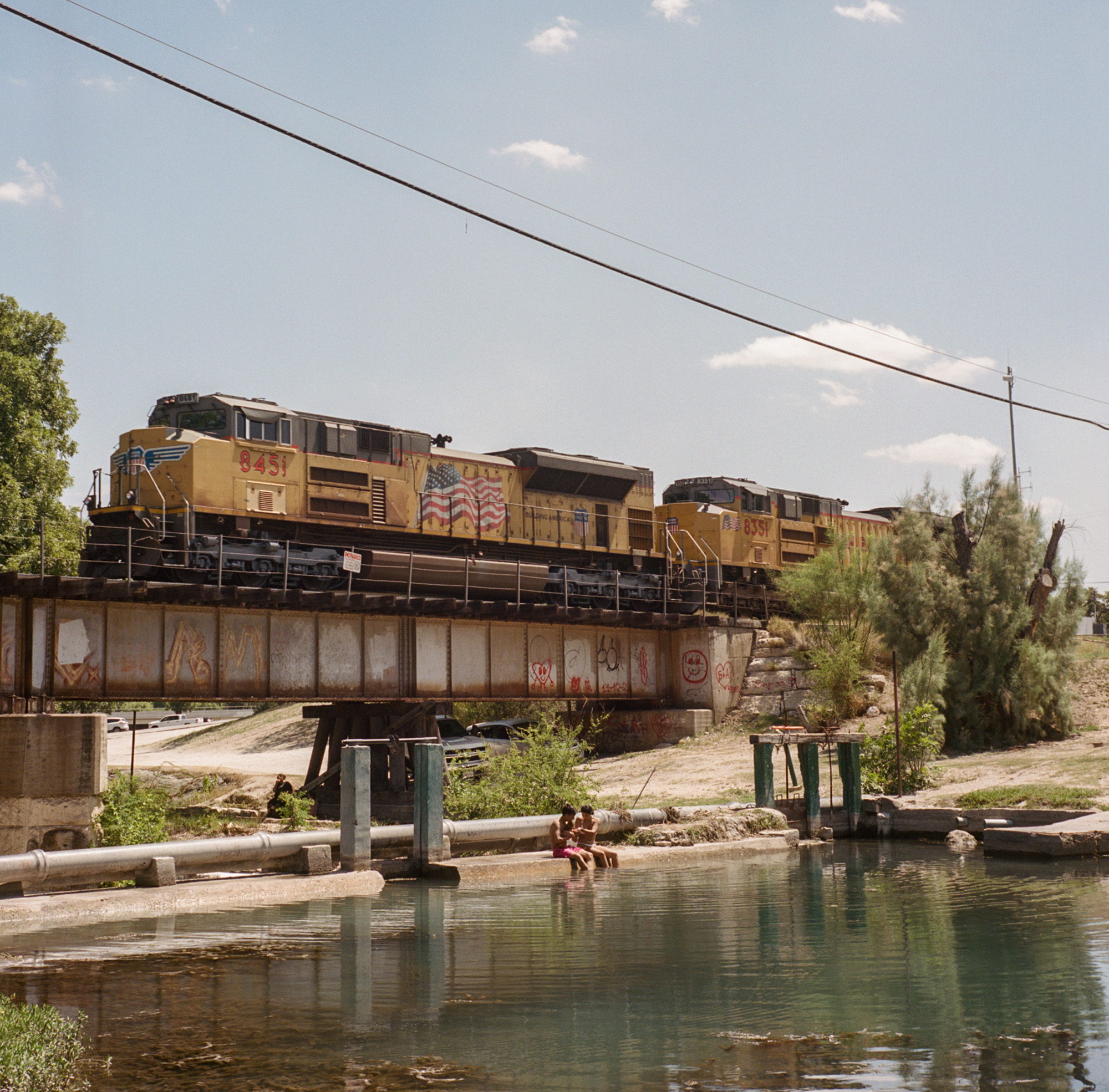 Train on a bridge going over a river.