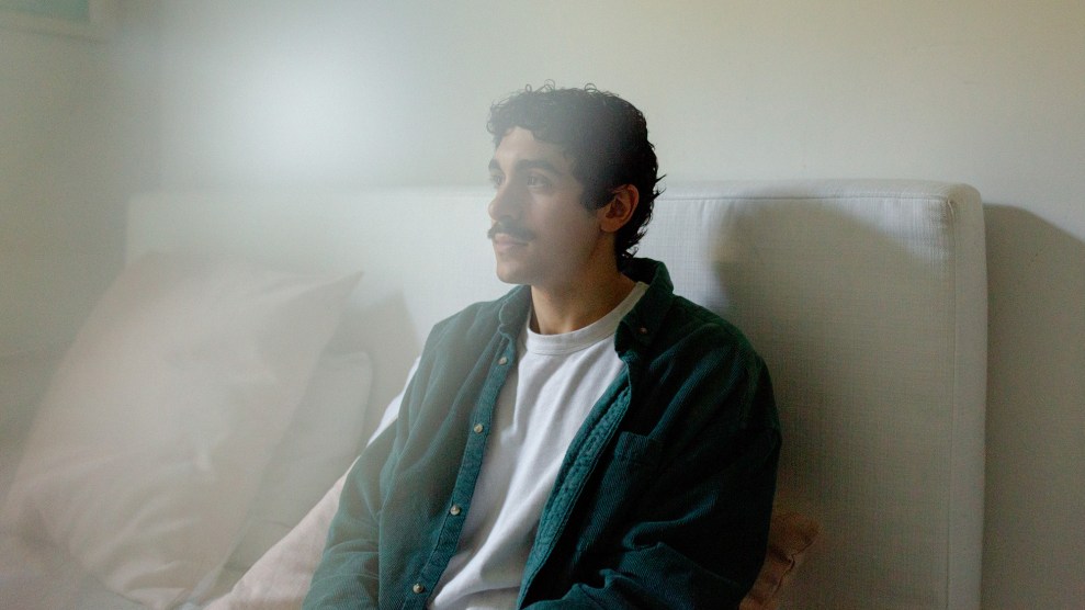 Portrait of man sitting on a bed.