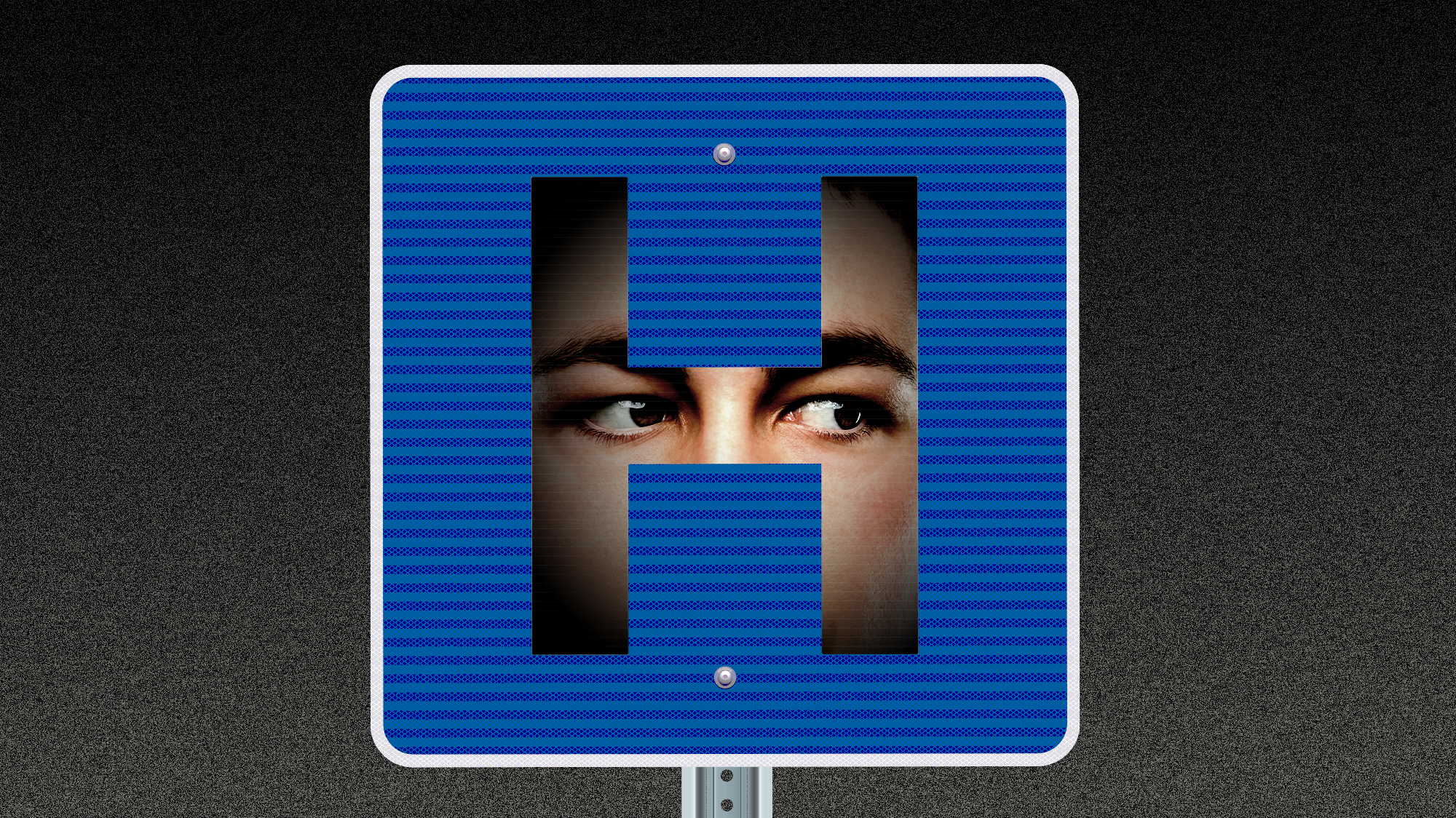 A hospital road sign in which there is a face hidden in the shadows behind the shape of the H. The eyes of the face appear to be staring intently to our right.