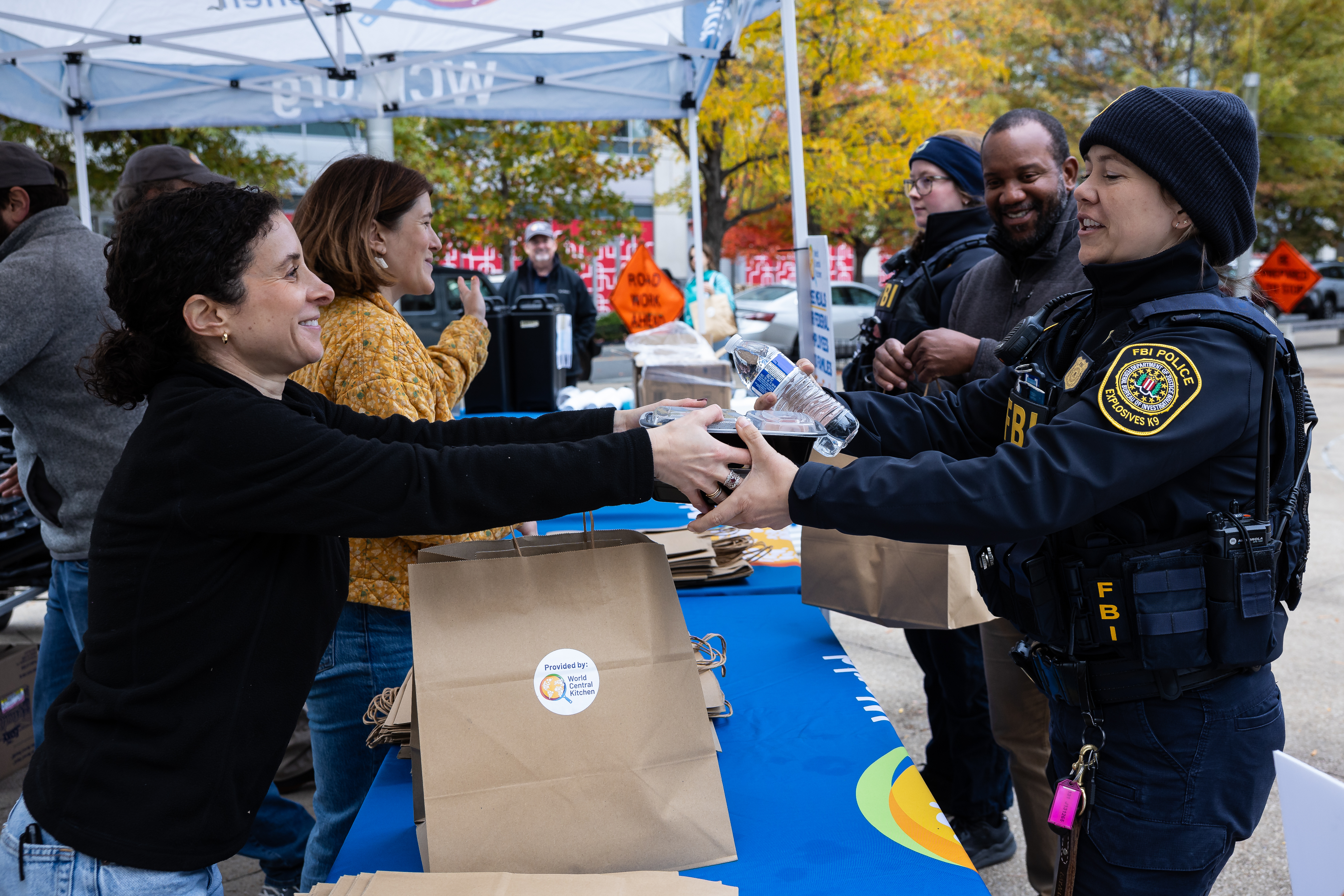 A worker from the World Central Kitchen hands a free meal to an FBI agent.