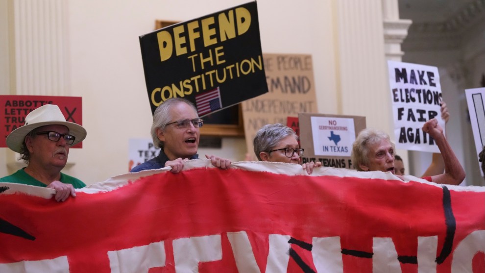 Protestors hold signs opposing gerrymandering inside the Texas state capitol as the legislature debates a new congressional map