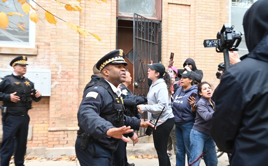 Law enforcement confronts crowd after ICE raid.