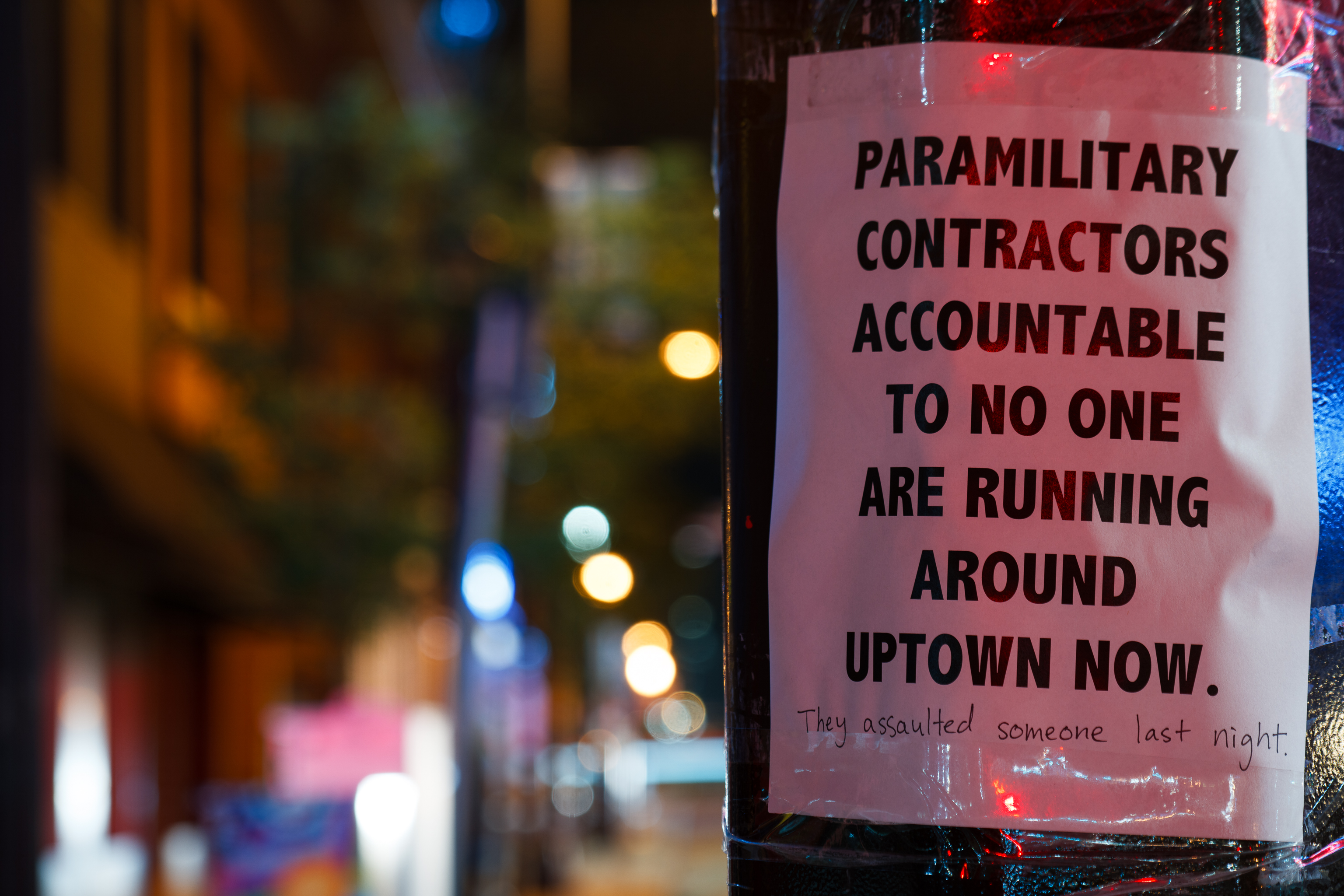 A sign protesting a paramilitary force in Uptown, taped to a pole.