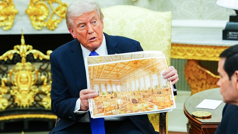 Donald Trump sits in the Oval Office, holding up a large architectural rendering of a golden ballroom to other people in the room. He sits in a chair upholstered in gold brocade fabric in front of a fireplace covered in gold ornamentation.