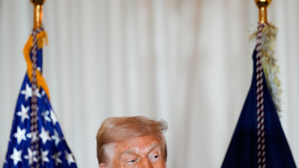 A photo of Donald Trump in front of two flags, with the bottom of the frame cutting off half his face