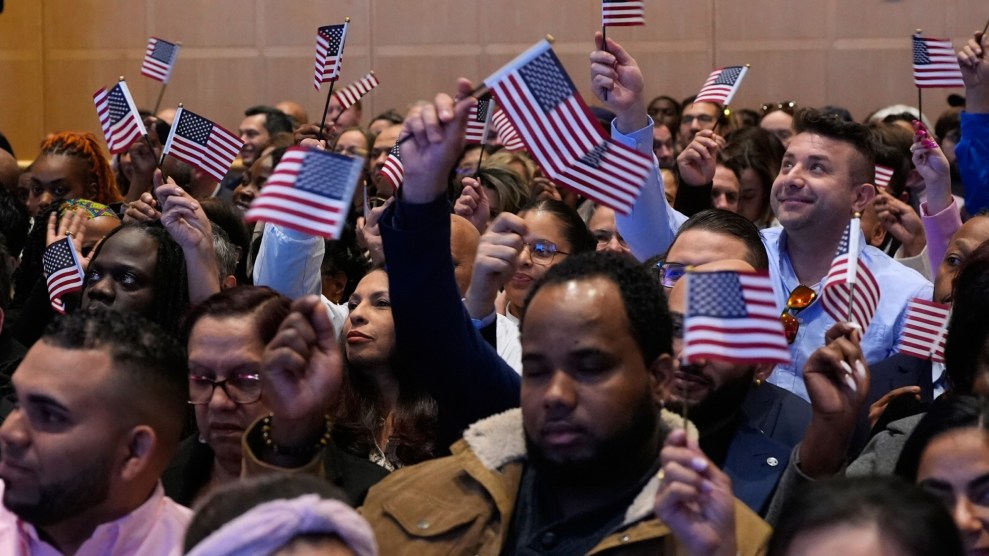 A group of men and women wave little US flags.
