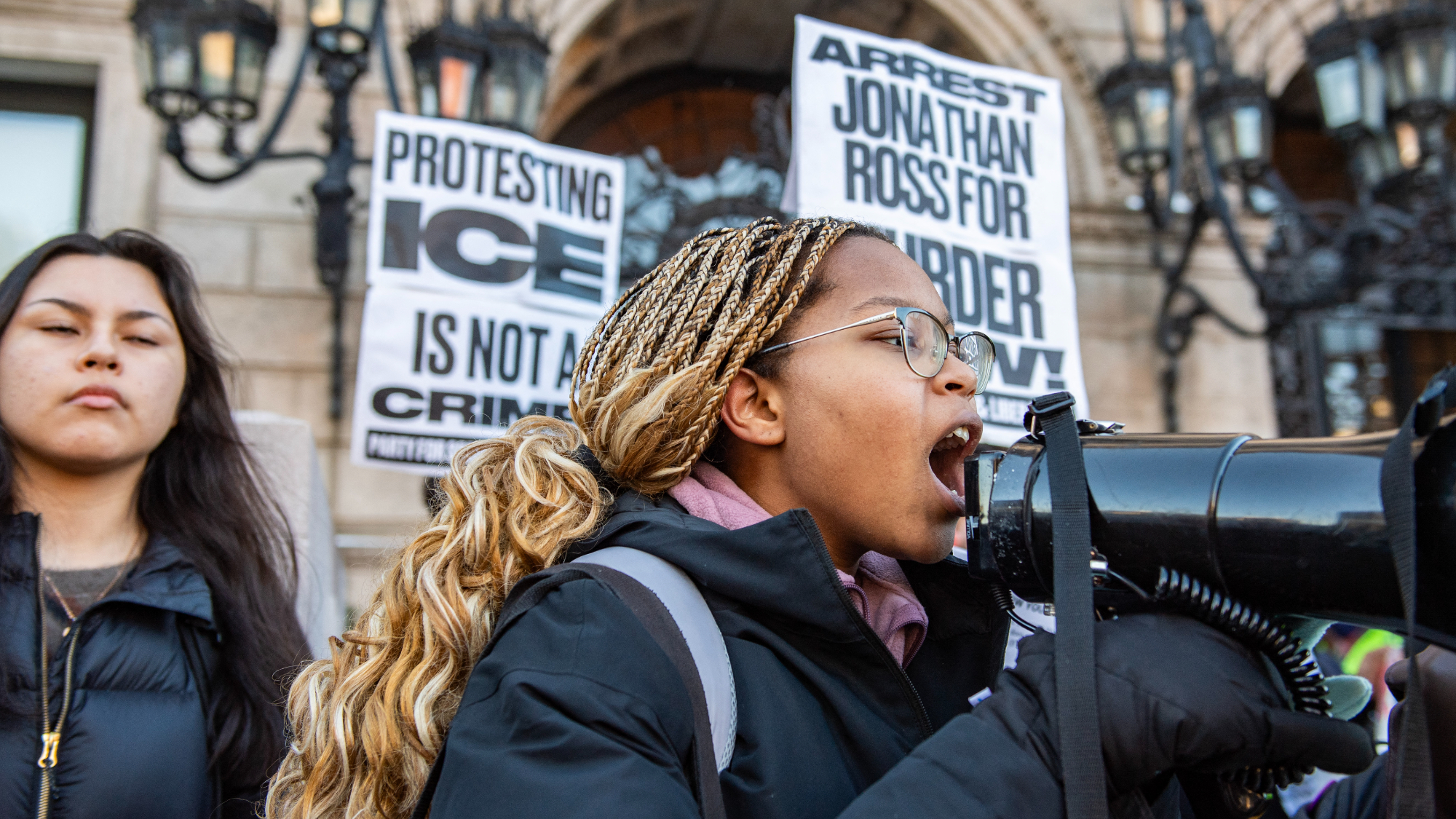 A woman on a megaphone speaks with people partaking in a "National Shutdown" protest against U.S. Immigration and Customs Enforcement in Boston, Massachusetts on January 30, 2026. 